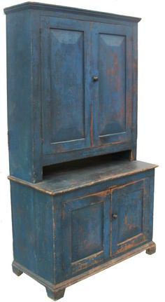 an old blue cabinet with two doors and a shelf on the bottom, sitting against a white background