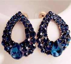 The darkest blue Austrian crystals flow in graduated sizes along a golden teardrop outline. The gold plated background creates contrast, making the blue even more alluring. A single pear shaped Austrian crystal emulates the shape of the earrings, becoming the focal point. In navy blue hues, these earrings can be dressed up or dressed down. They are totally versatile and easy to wear. Size 2.5 x 2 cm (approximately 1 inch x 1/2 inch) Materials: Gold Plated/Alloy Stones: Rhinestones Post Earrings, Blue Pear-shaped Teardrop Earrings, Blue Pear-shaped Party Earrings, Blue Crystal Teardrop Earrings, Blue Crystal Earrings, 여름 스타일, Punk Jewelry, Stone Gold, Crystal Stud Earrings, Big Earrings