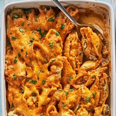 a casserole dish filled with pasta and meat, garnished with parsley