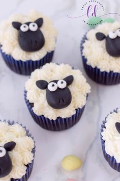 some cupcakes with white frosting and black sheep faces