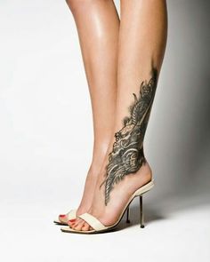 a woman's legs with tattoos and high heels