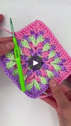 someone is crocheting a square with a green needle