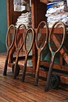 tennis rackets are lined up in front of a pile of shirts and cloths