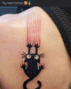 a cat tattoo on the back of a woman's upper arm, with red streaks coming out of it