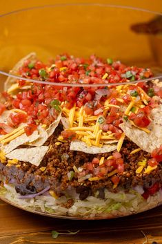 a bowl filled with taco salad and tortilla chips on top of it