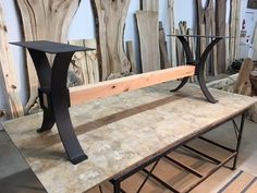 a wooden bench sitting on top of a table next to other wood pieces in a room