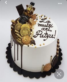 a birthday cake decorated with cookies, chocolates and other treats on a white surface