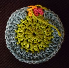 a crocheted object is sitting on the floor in front of a black background