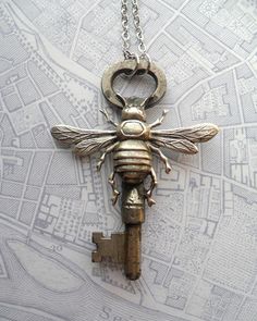 a key with a bee on it hanging from a chain