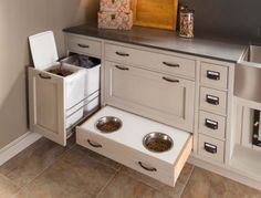 an open drawer in the kitchen with two bowls and one bowl on it's side