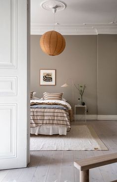 a bed room with a neatly made bed and a wooden bench