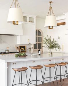 a kitchen island with four stools next to it and a vase on the counter