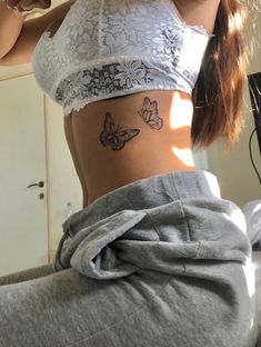 a woman with a butterfly tattoo on her stomach