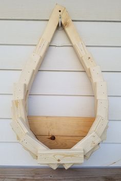 a wooden frame hanging on the side of a house with wood planks around it