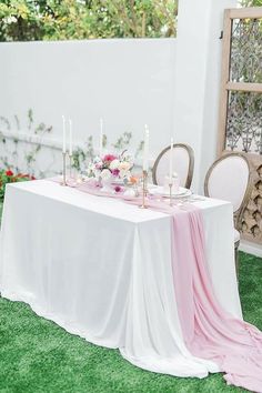 the table is set with candles, flowers and napkins for an elegant wedding reception