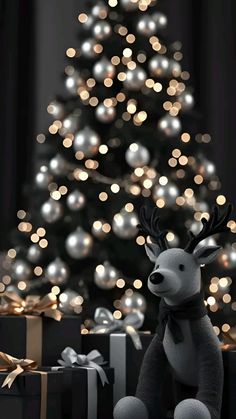 a stuffed reindeer sitting in front of a christmas tree