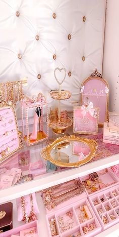 there are many pink and gold items on the shelf in this room that is filled with jewelry