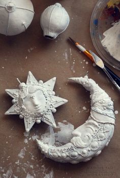 the moon and star are made out of clay, with paintbrushes next to it