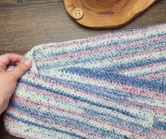 someone is stitching together a blanket on top of a wooden table next to a bowl