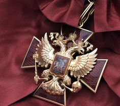 a gold and red cross with an eagle on it's center piece is shown