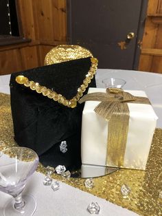 black and white gift bags with gold sequins on the top are sitting on a table