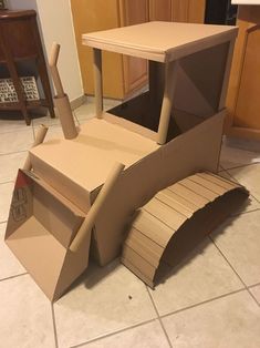 a cardboard construction vehicle sitting on the floor