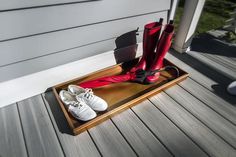 two pairs of red umbrellas sitting on top of a wooden tray next to white shoes