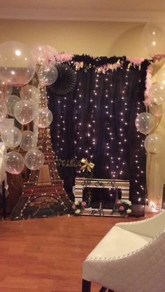 a room decorated with balloons, streamers and an eiffel tower in the background