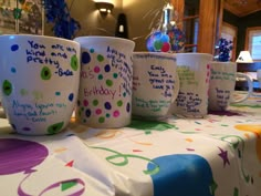 there are many coffee cups on the table with birthday messages written on them and confetti sprinkles