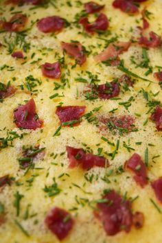 a pizza with cheese, ham and herbs on it