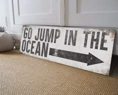 a sign that says go jump in the ocean with an arrow pointing to the right