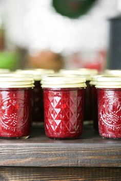 red jars with white lids are lined up on a table