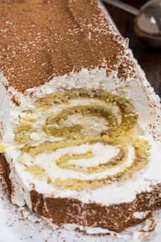 a cake with white frosting and brown sprinkles sitting on a plate