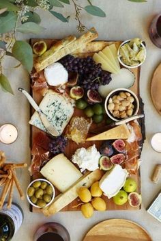 a table topped with lots of different types of cheese and meats on top of it