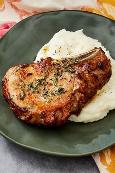 a green plate topped with meat and mashed potatoes