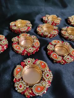 several red and gold plates sitting on top of a black cloth