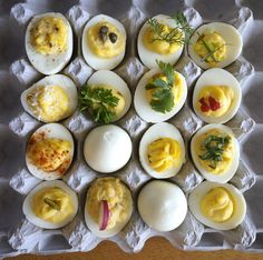 an arrangement of deviled eggs with different toppings on them, arranged in a grid pattern