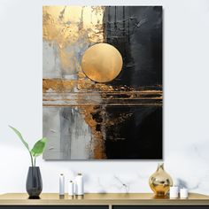 an abstract painting in gold and black on a wall above a console table with candles