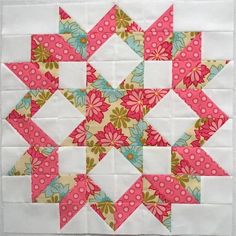 a pink and white quilted block with flowers on the front, along with two blocks in the middle