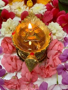 a lit candle surrounded by flowers and petals