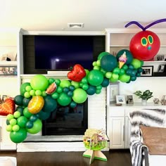 a very large balloon decoration in the shape of a caterpillar with fruit on it