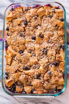 a casserole dish filled with blueberries and crumbled bread