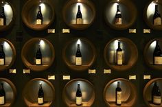 several bottles of wine are displayed on wooden shelves