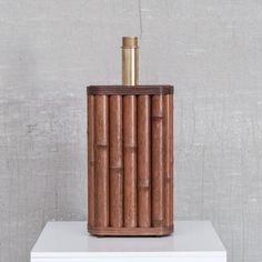 a wooden bottle holder sitting on top of a white table next to a gray wall