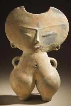 an old clay sculpture with two faces on it's back and one face in the middle