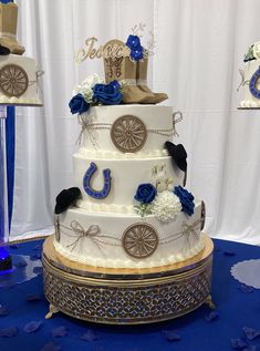 a three tiered wedding cake decorated with blue flowers and an old fashioned cowboy hat