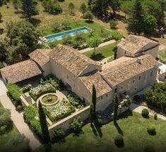 an aerial view of a large house surrounded by trees and bushes with a pool in the middle