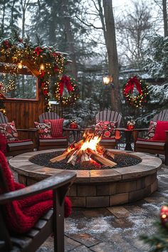 a fire pit surrounded by chairs and christmas wreaths on the trees in the background