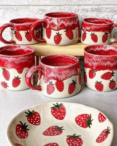 red and white ceramic strawberry mugs with matching plates