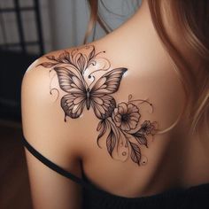 the back of a woman's shoulder with flowers and butterflies on it